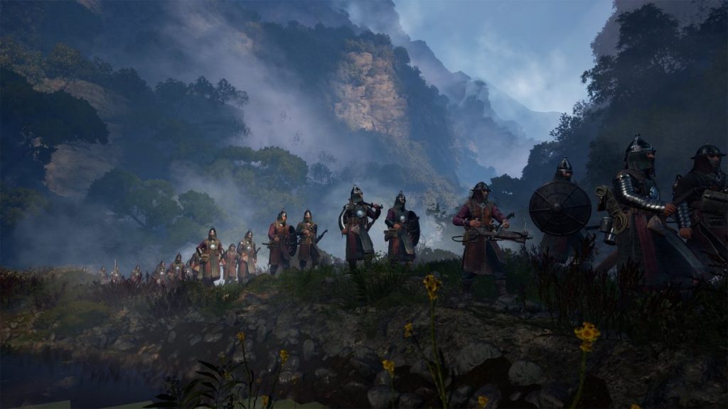 Des soldats marchant dans un paysage montagneux brumeux, vêtus d'armures médiévales.