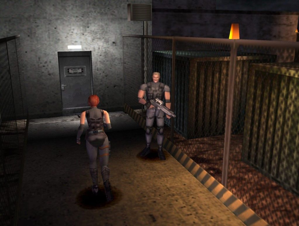 Deux personnages armés évoluant dans un environnement sombre et industriel, l'un entrant par une porte, l'autre attendant avec une arme.