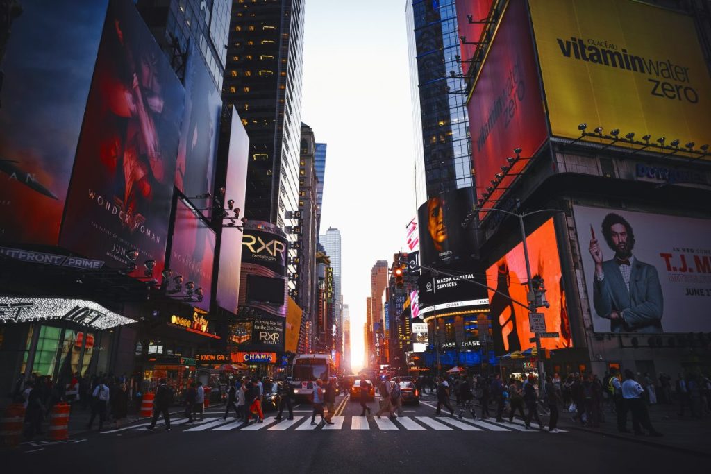 Vue de Times Square avec des panneaux publicitaires lumineux au crépuscule.