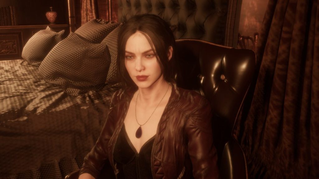 Une femme assise sur une chaise en cuir, portant un haut noir et une veste en cuir marron, avec des cheveux bruns et un collier, dans une chambre au décor élégant.